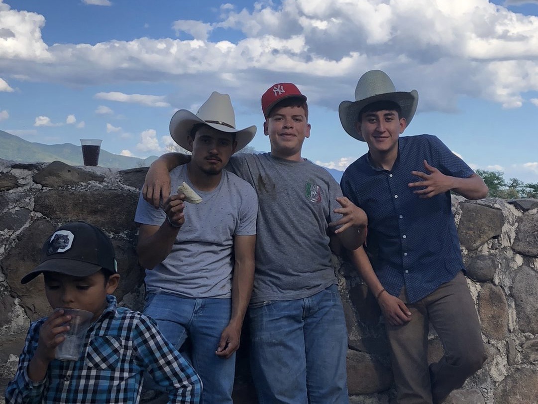 Imagen de referencia de Los Cachorros del Rodeo: cuatro jóvenes posan frente a un muro de piedra bajo un cielo azul